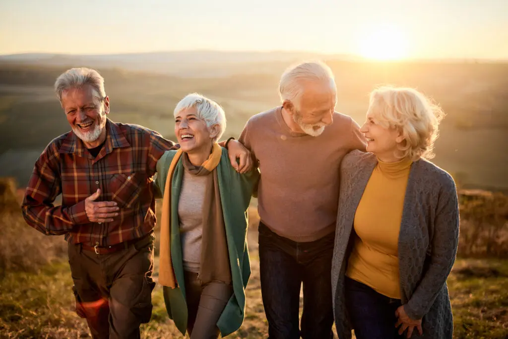 A group of older adults go for a walk during sunset
